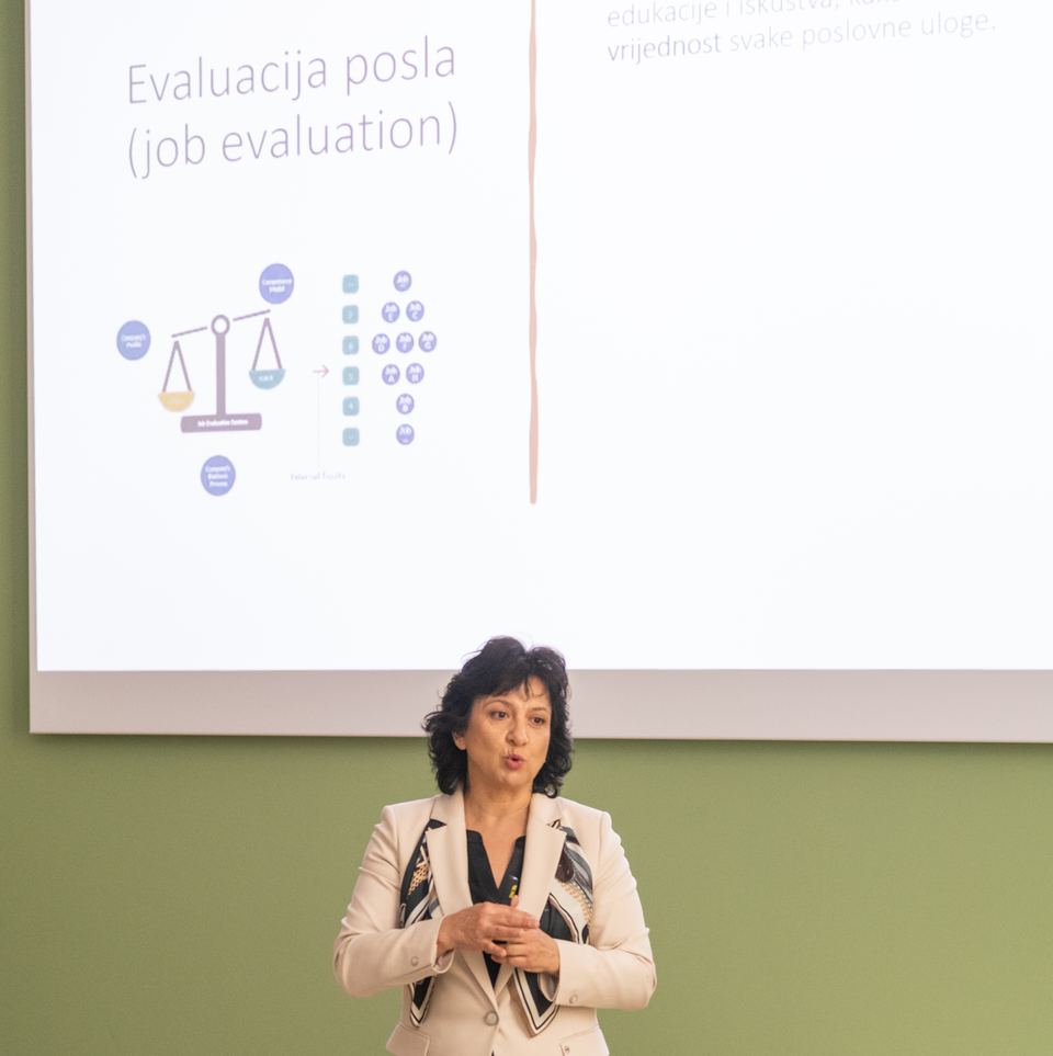 Jasna Rilović vodi radionicu; na platnu je slajd „Evaluacija posla (job evaluation)”.