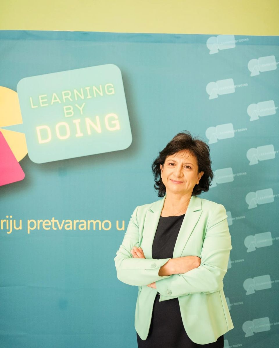 Jasna Rilović ispred zida s logotipom akademije Learning by Doing.